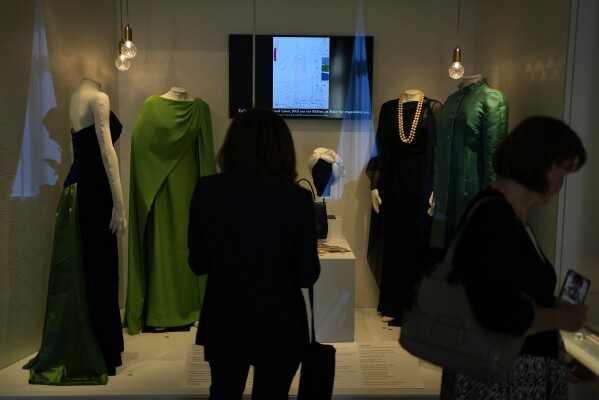 Two women look the dresses of Greek Soprano Maria Callas at the newly established Museum, the first dedicated to the legendary opera star, in Athens, Greece, Wednesday, Oct. 25, 2023. The new museum presents, priceless historical artifacts, including photographs and portraits, rare live recordings, and a unique collection of records and personal items as this year is the 100th anniversary of Maria Callas' birth. (AP Photo/Thanassis Stavrakis)